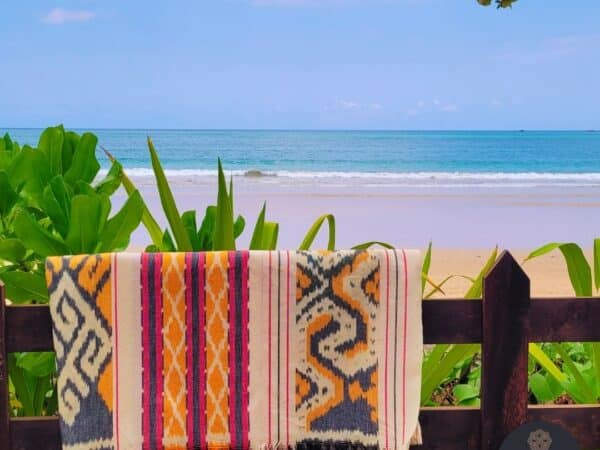 Ikat Bali Handgewebte Ikatdecke mit geometrischen Mustern in grau, pink und orange auf beigem Grund